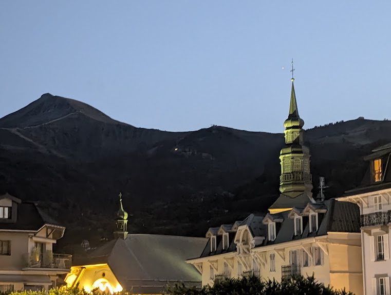 The church in Saint-Gervais lit up at dusk, with the Aravis mountain range in the background