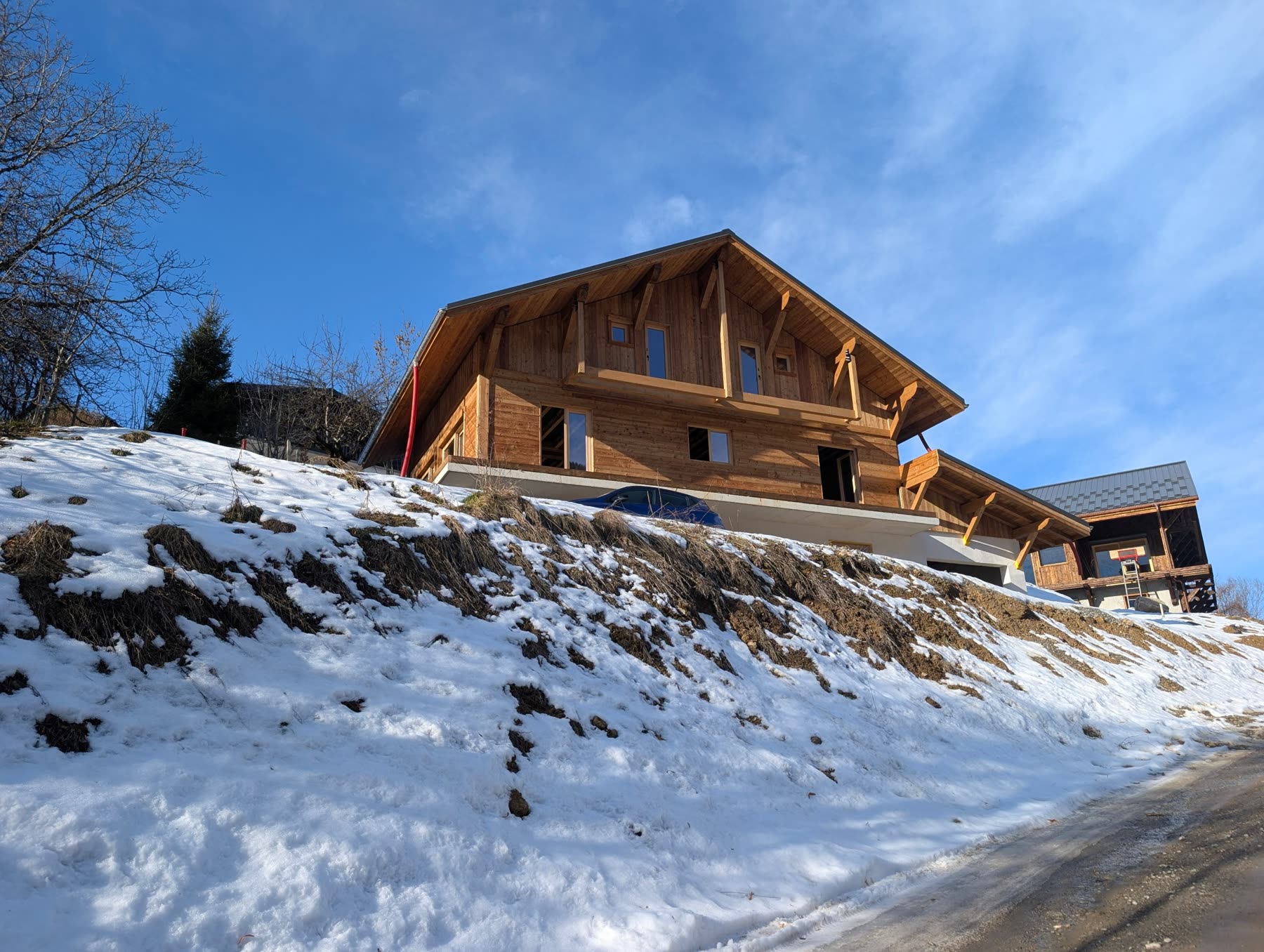 Chalet Miage's timber gable rising above a snowy bank in winter